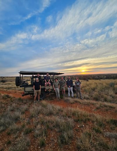 Students in the veld with a field safari vehicle